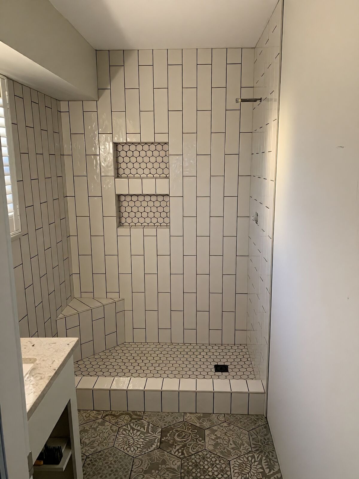 Walk-in tiled shower with built-in bench and niche