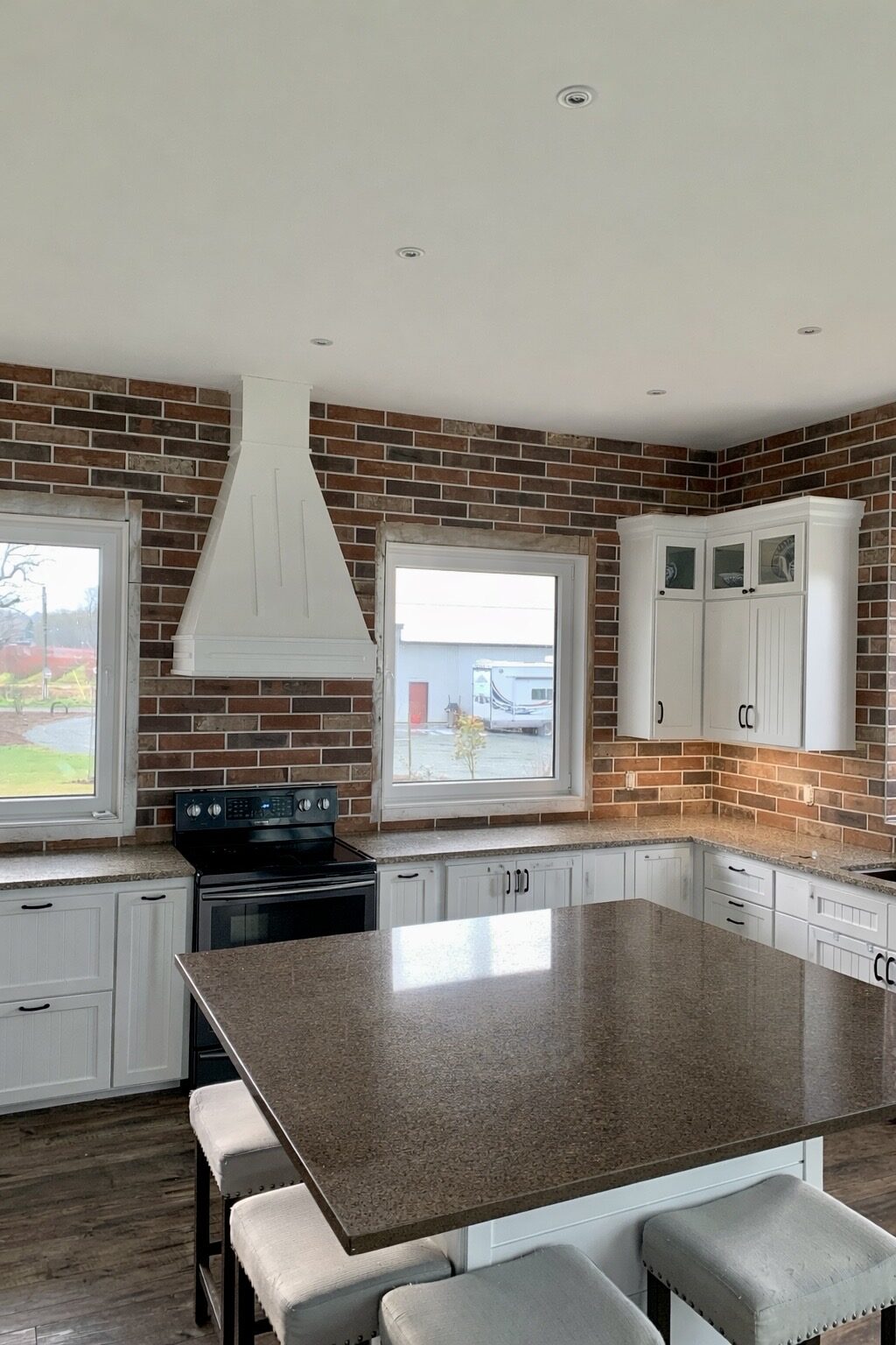 Kitchen with a full brick backsplash and range hood