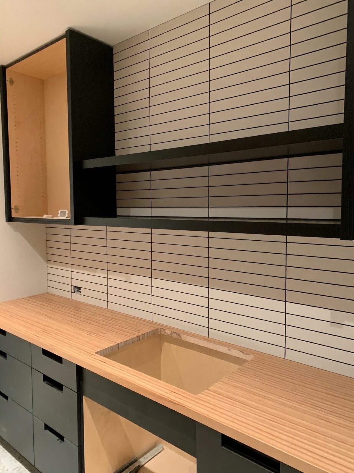 Full-wall linear tile backsplash with black open shelving