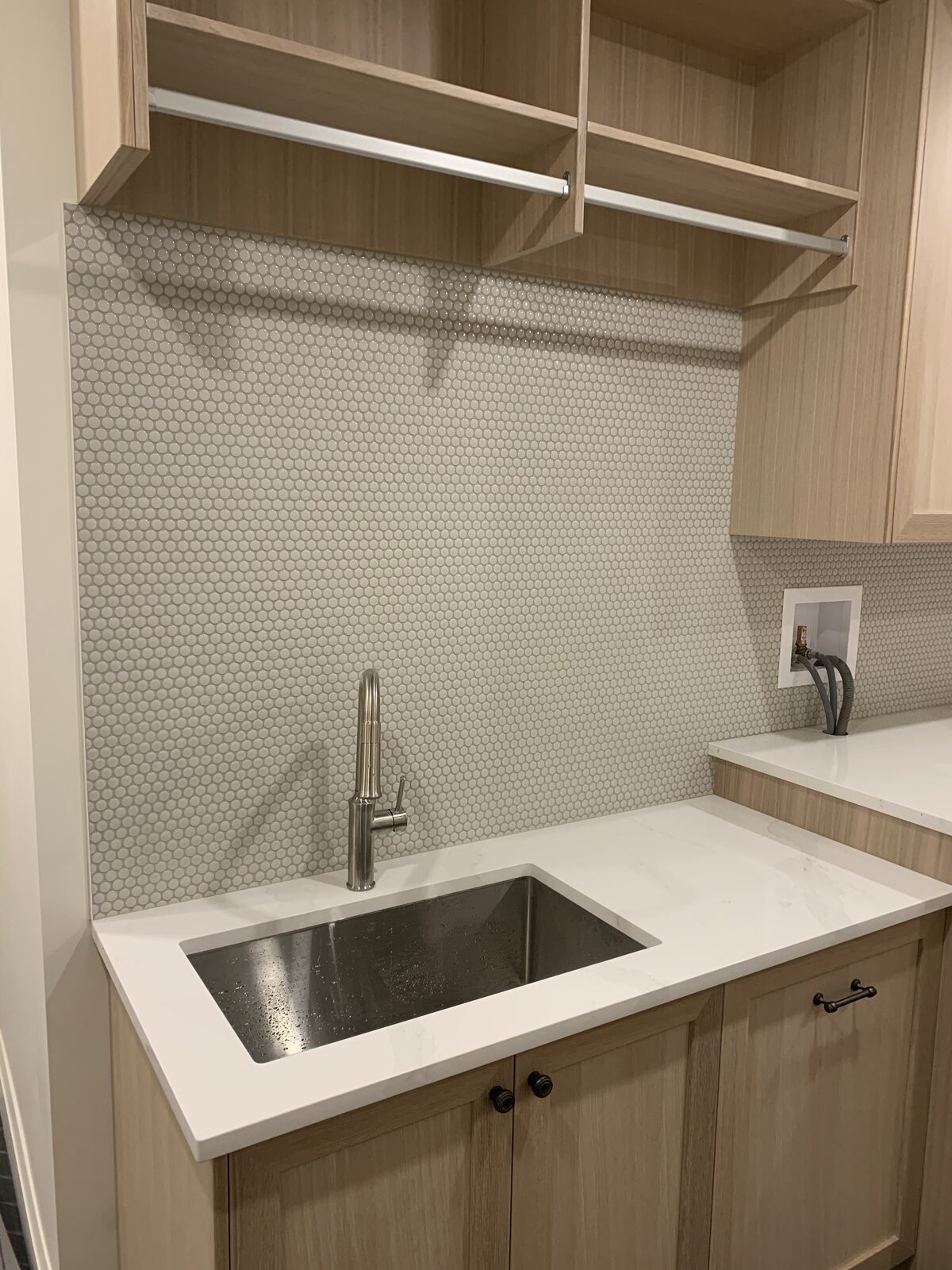 Penny round mosaic backsplash behind a kitchen sink