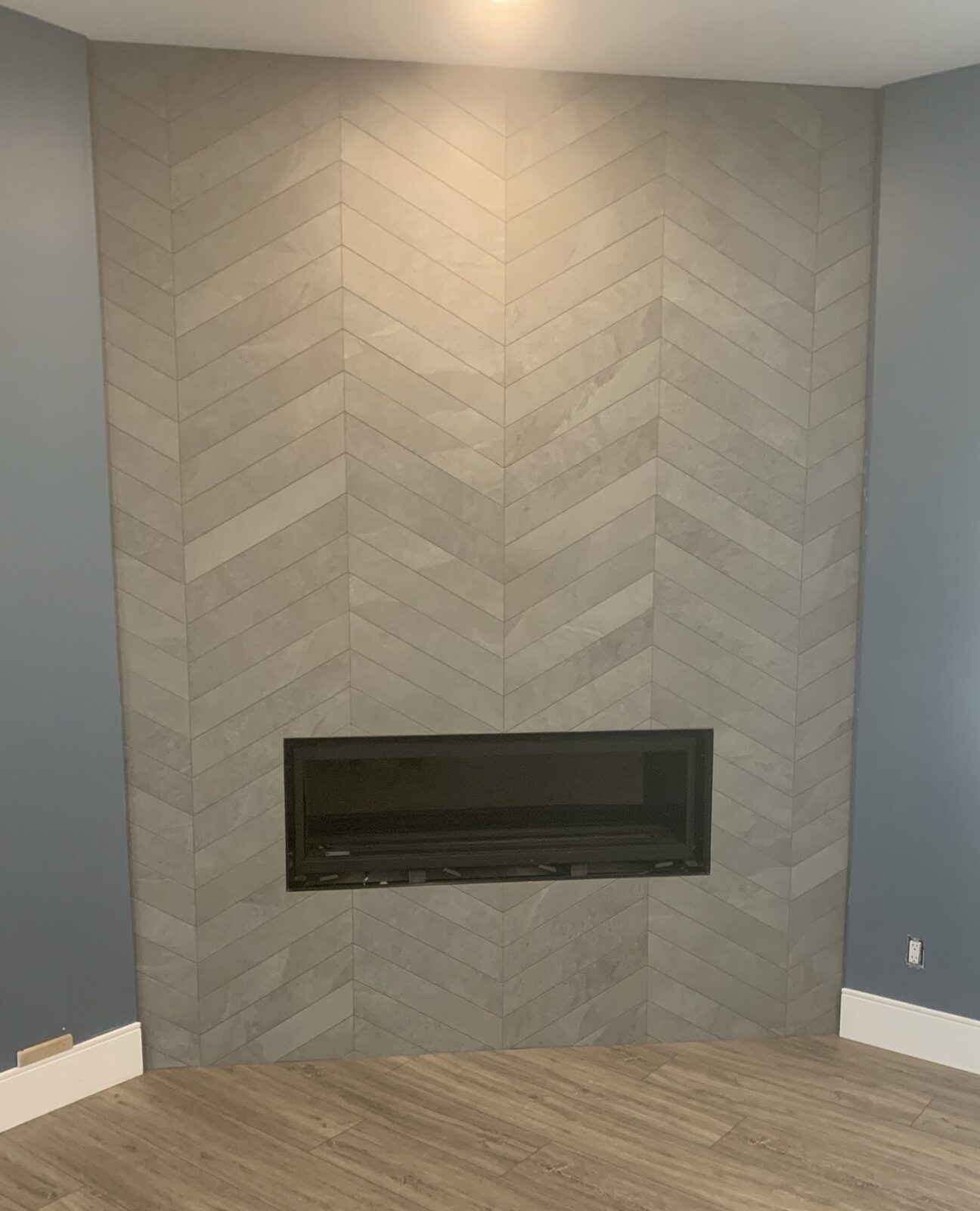 Chevron tile fireplace wall with a linear insert