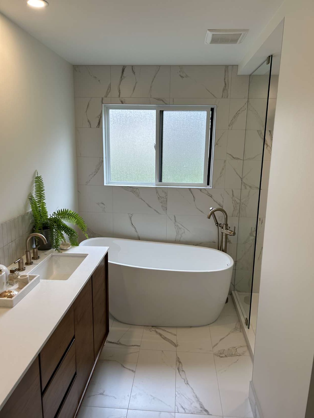 Marble-look tiled bathroom with freestanding tub