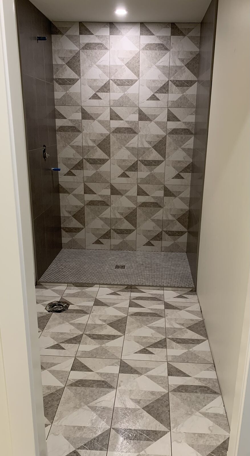 Walk-in shower with a geometric patterned feature wall