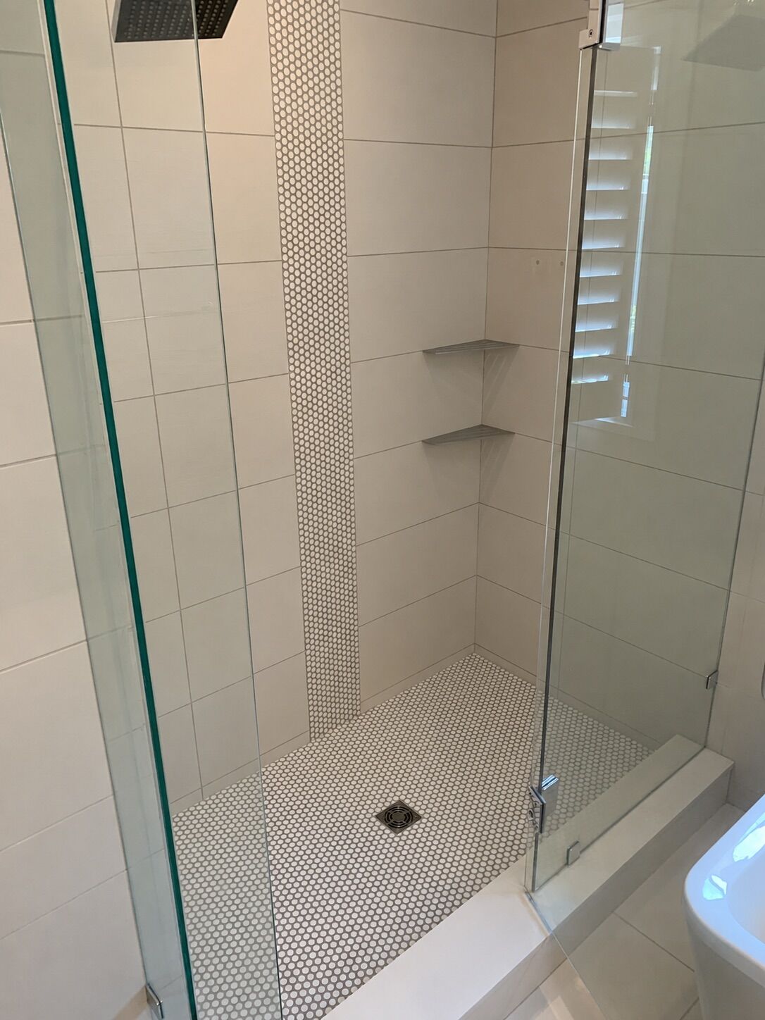 Walk-in shower with a penny mosaic feature strip and floor