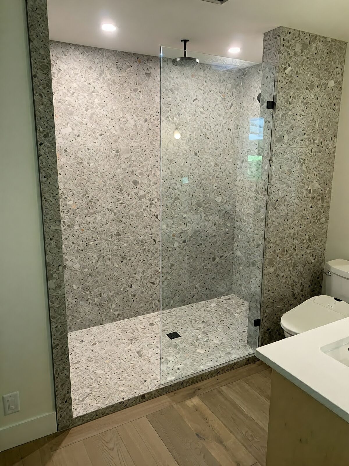 Frameless walk-in shower in terrazzo-look slabs