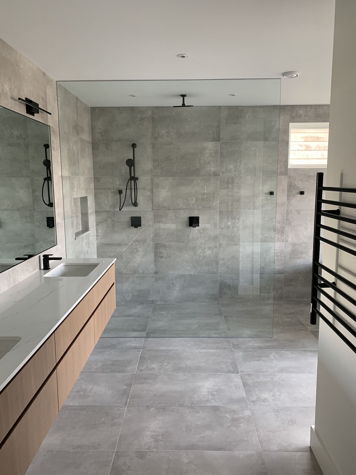 Concrete-look ensuite with a walk-in shower and niche