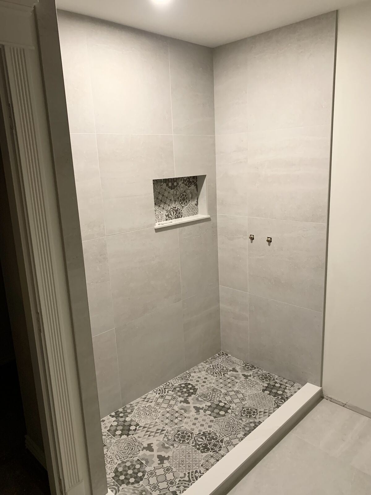 Shower with a patterned floor and matching patterned niche